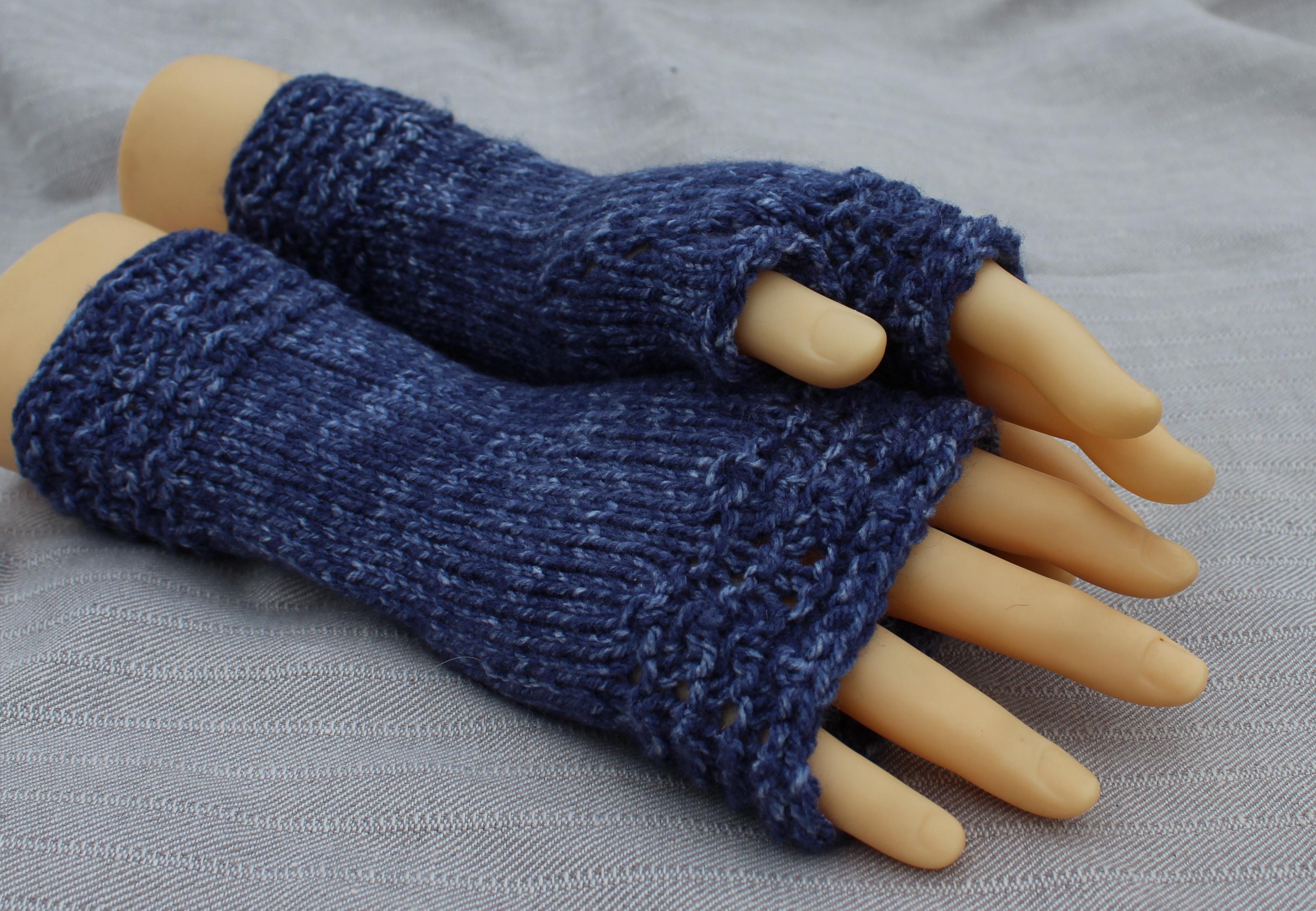 Blue knitted fingerless gloves on a mannequin hand against a gray background