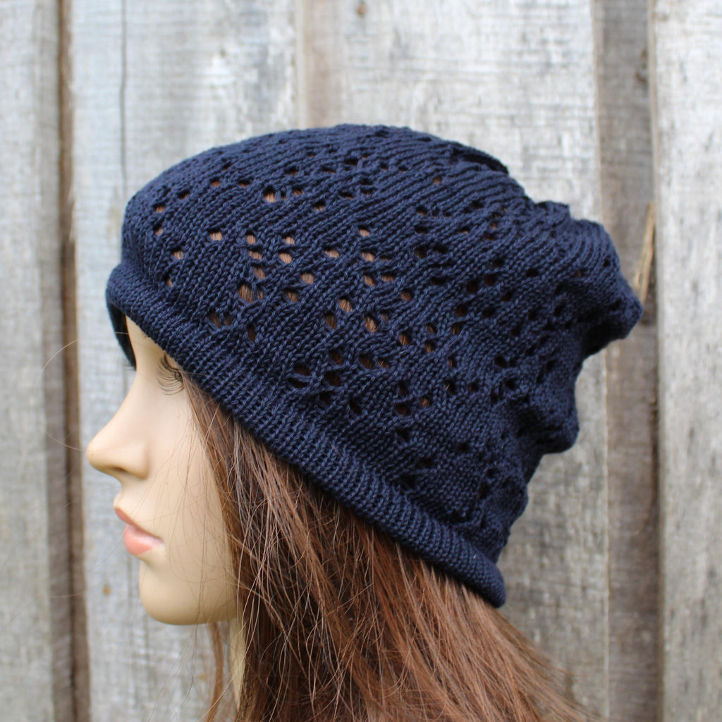 Navy blue knitted beanie worn by a mannequin against a wooden background