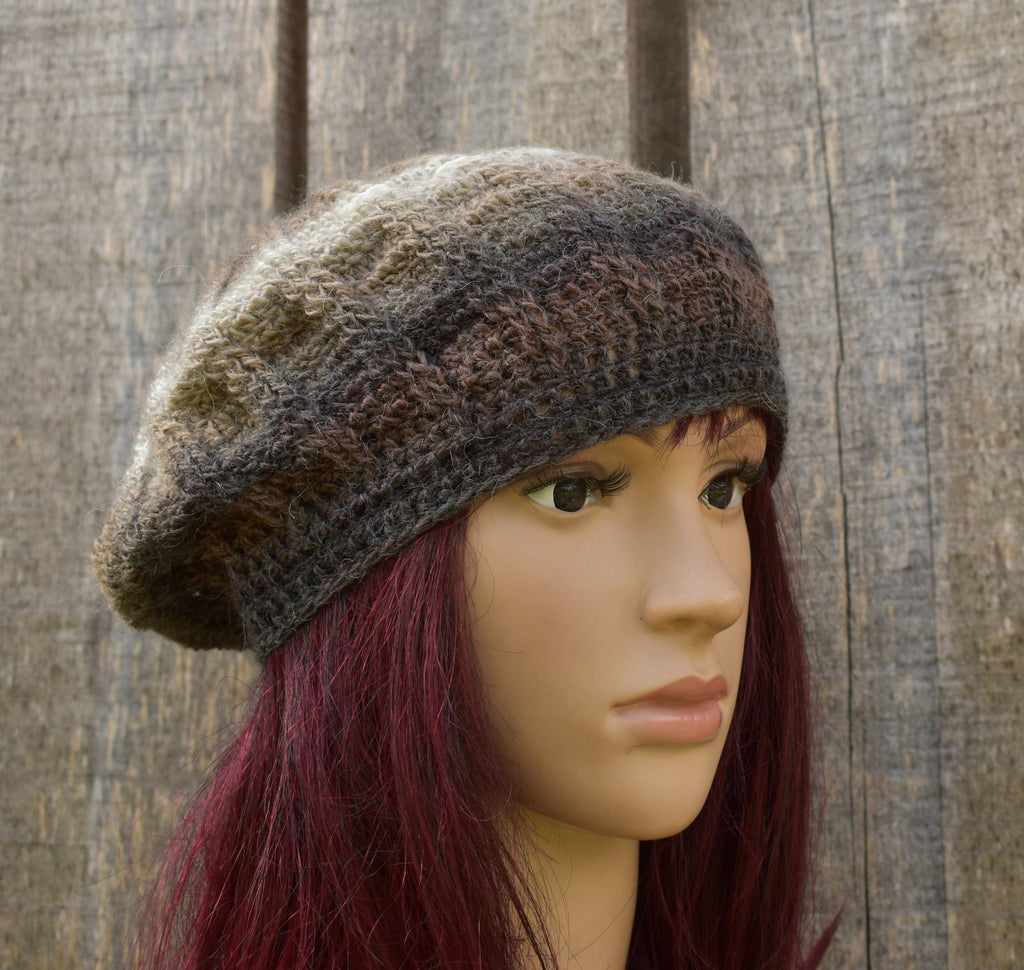 Knitted brown beret on a mannequin head against a wooden background