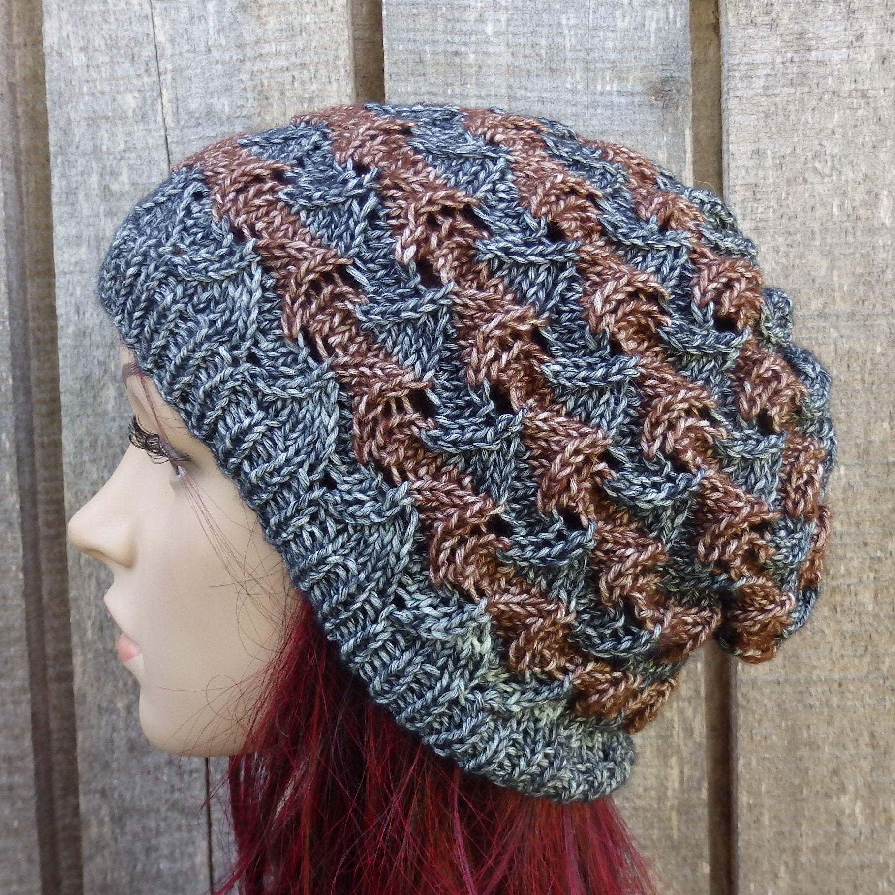 Knitted hat with a wavy pattern worn by a mannequin against a wooden background