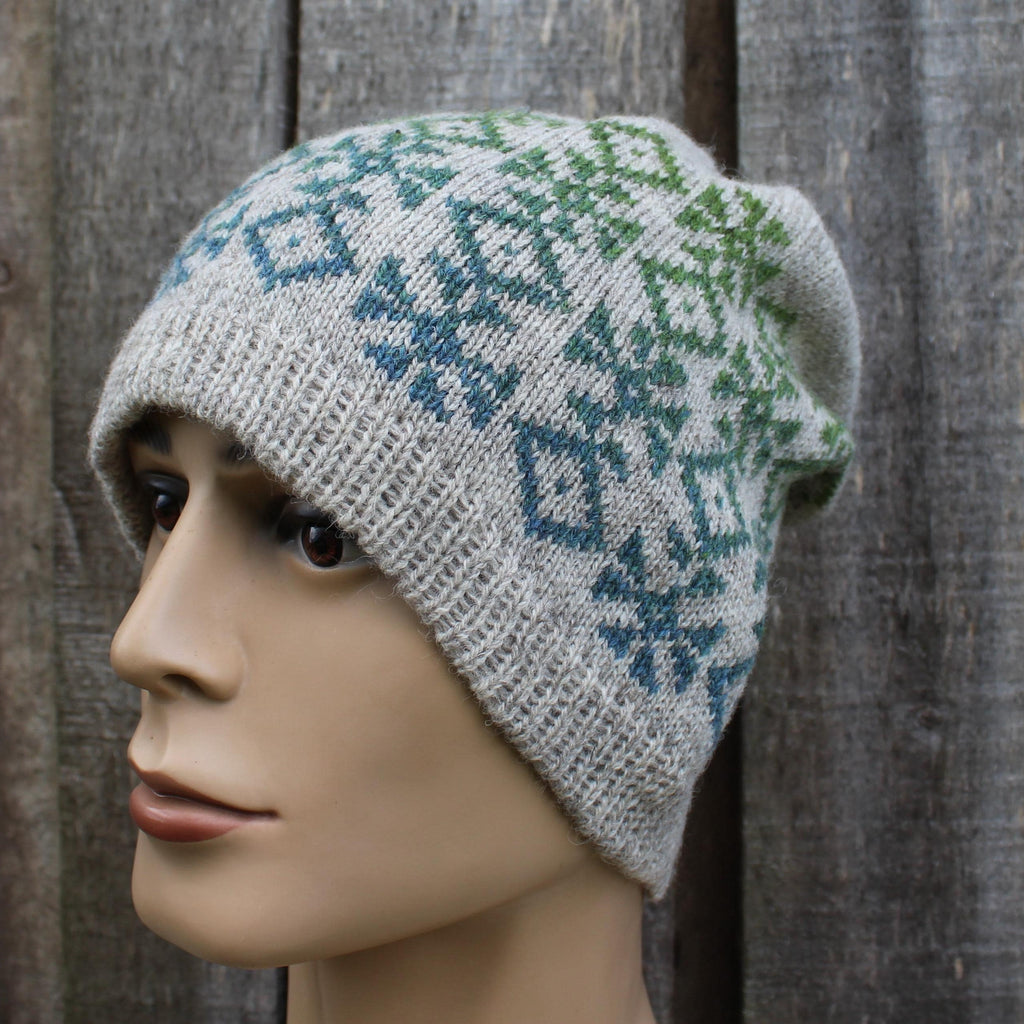Knitted hat with a pattern on a mannequin head against a wooden background