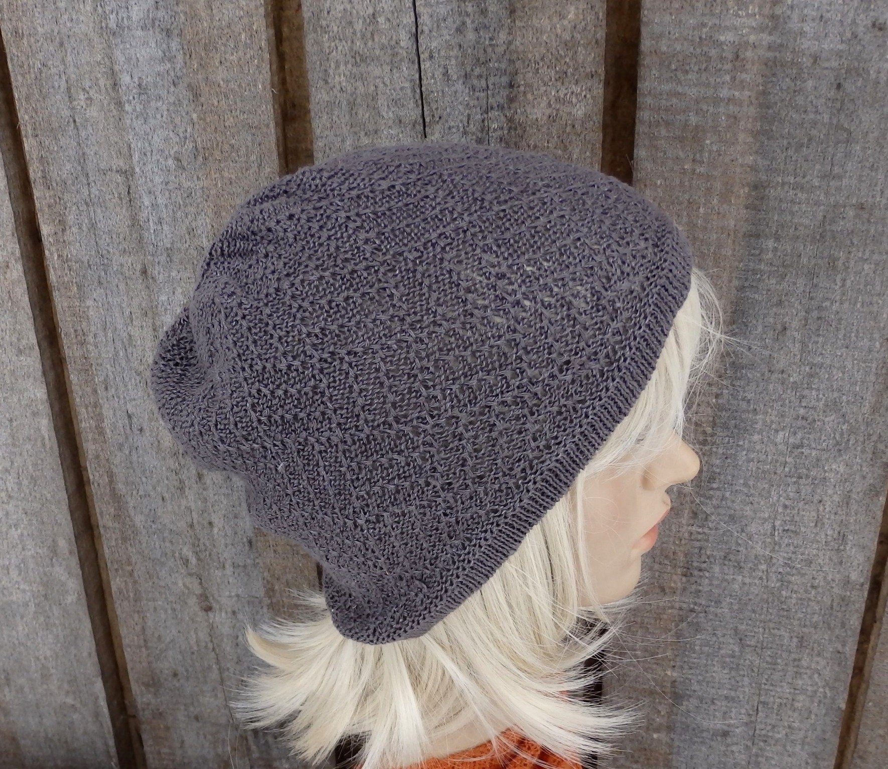 Gray knit beanie on a mannequin head against a wooden background