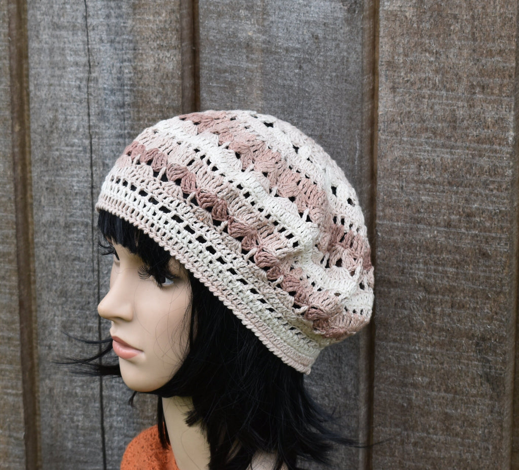 Woman wearing a crocheted hat against a wooden background