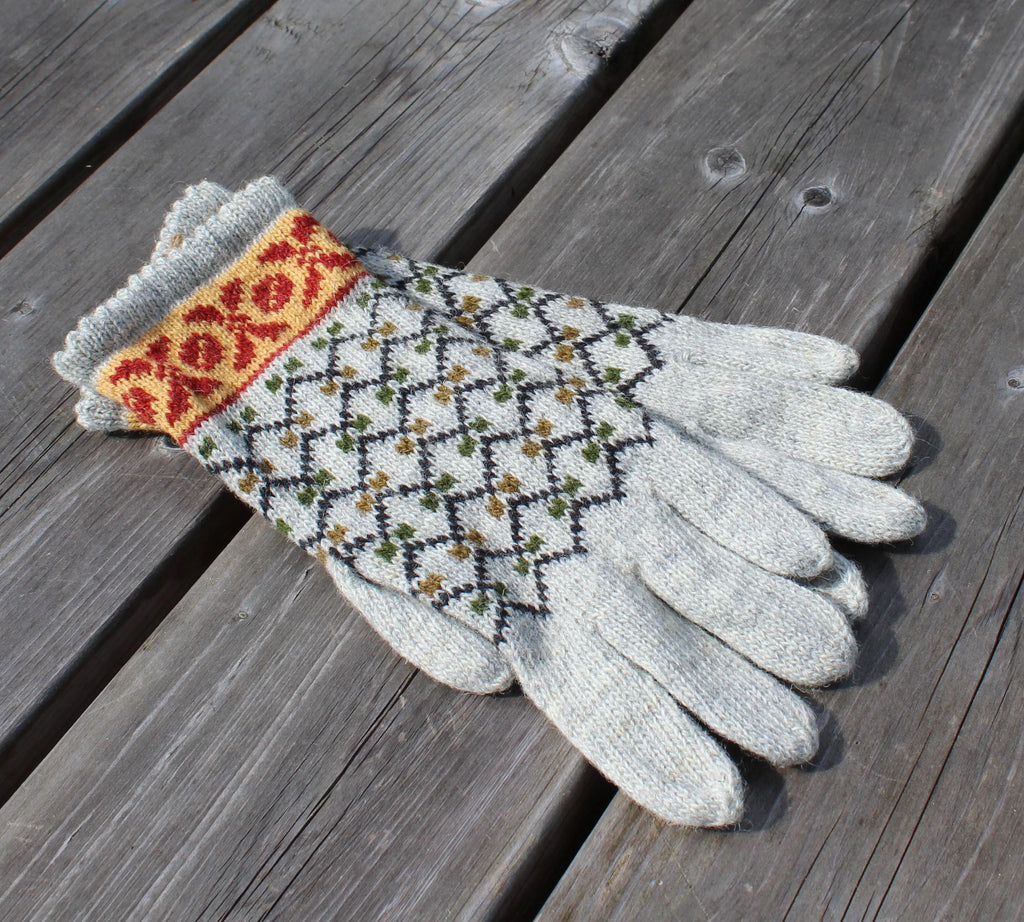 Pair of gloves with a patterned cuff on a wooden surface