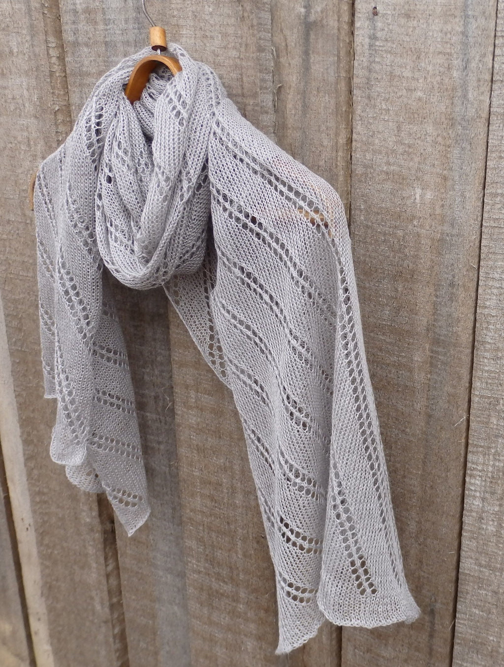 Knitted shawl draped over a wooden surface