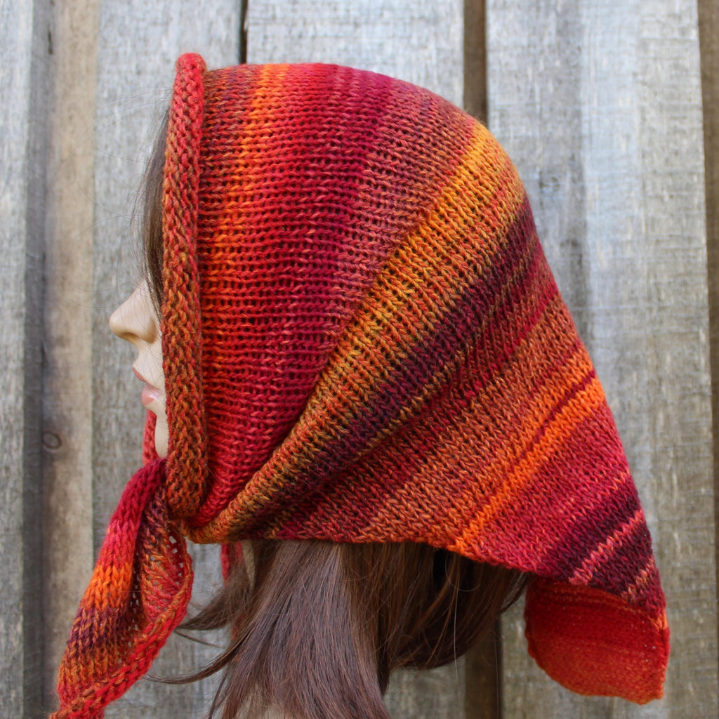 Person wearing a red and orange striped knitted headscarf against a wooden background