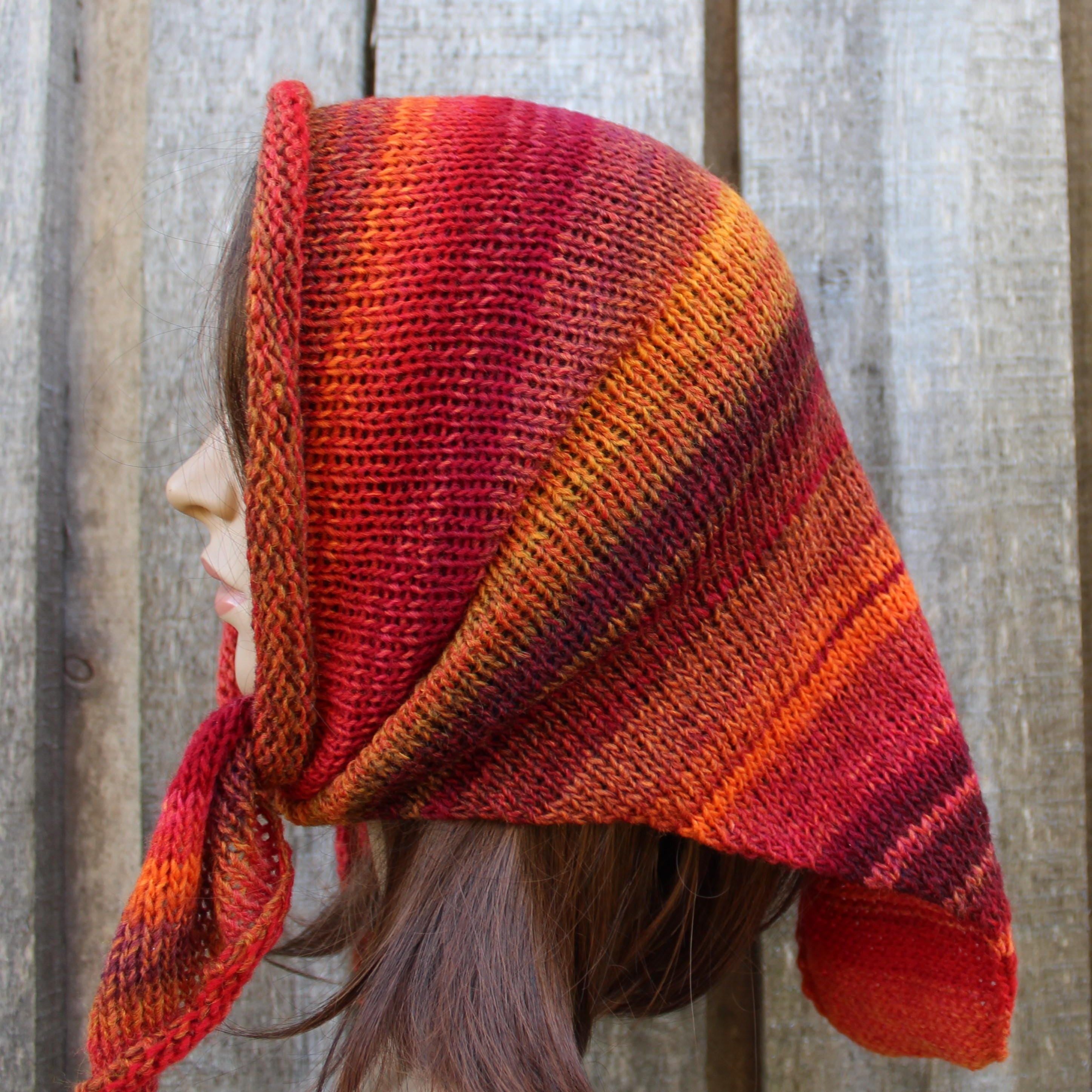 Person wearing a red and orange striped knitted headscarf against a wooden background