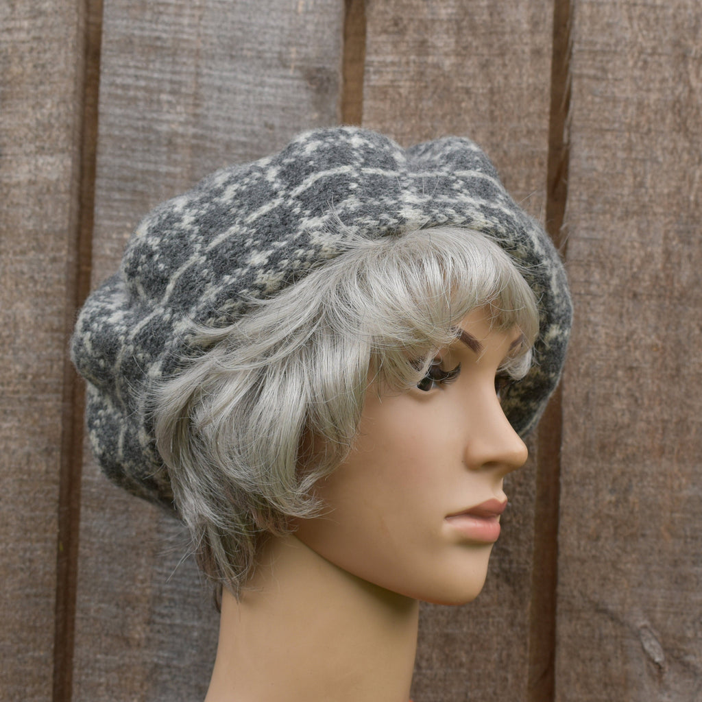 Mannequin head with gray knit hat and white wig against a wooden background