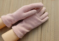 Pair of pink gloves on a wooden surface