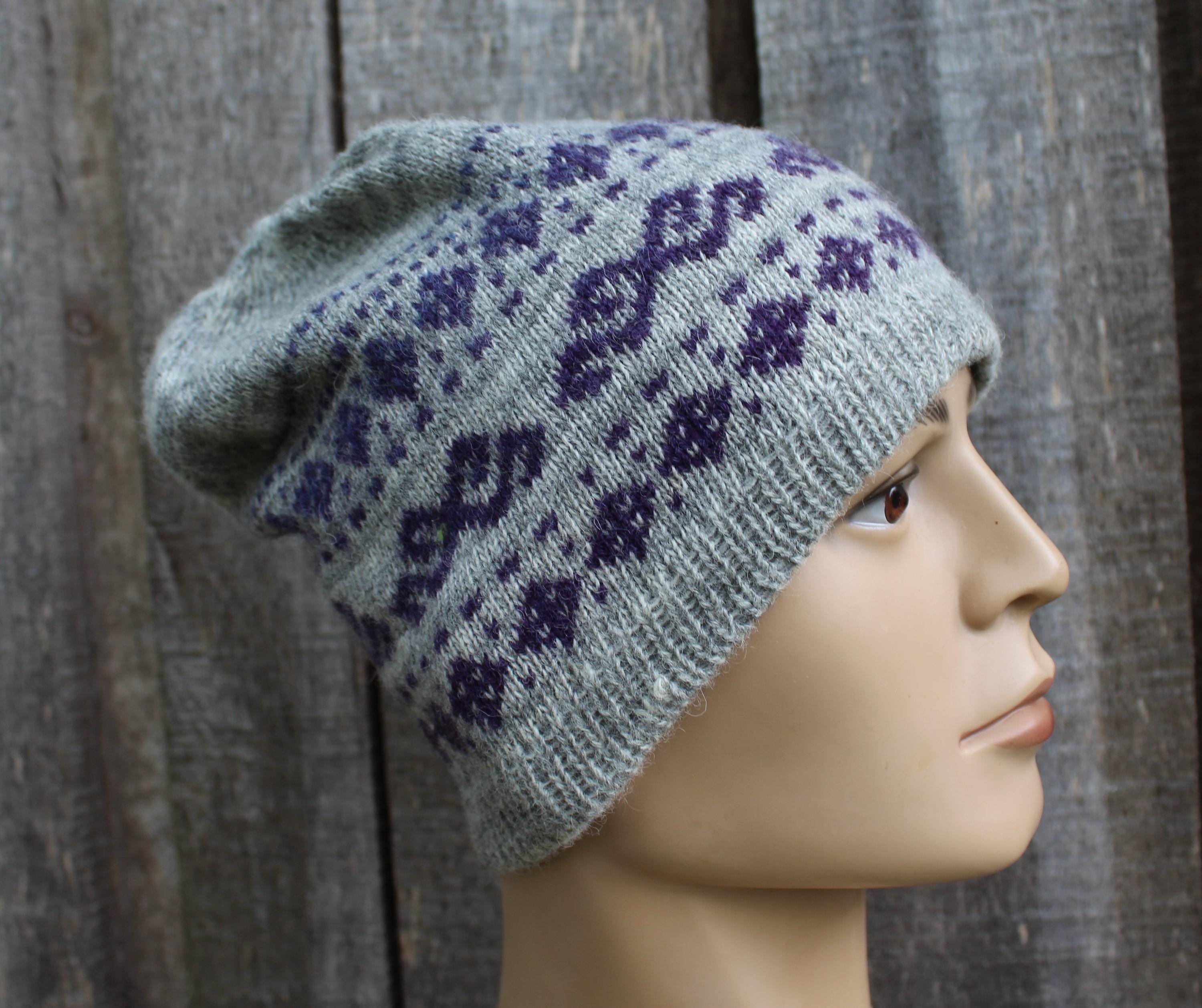 Gray knit beanie with purple pattern on a mannequin head against a wooden background