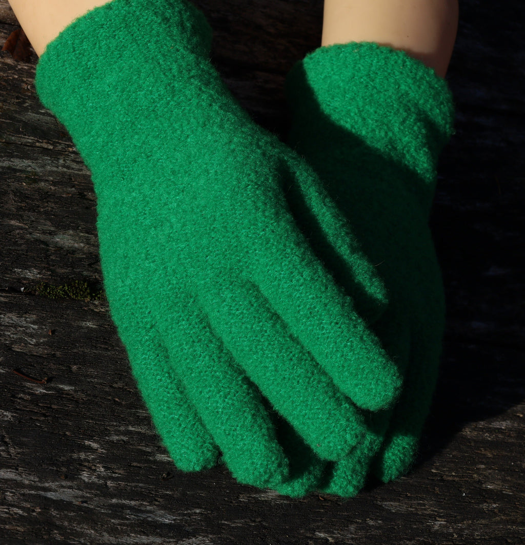 Green gardening gloves on a dark wooden surface