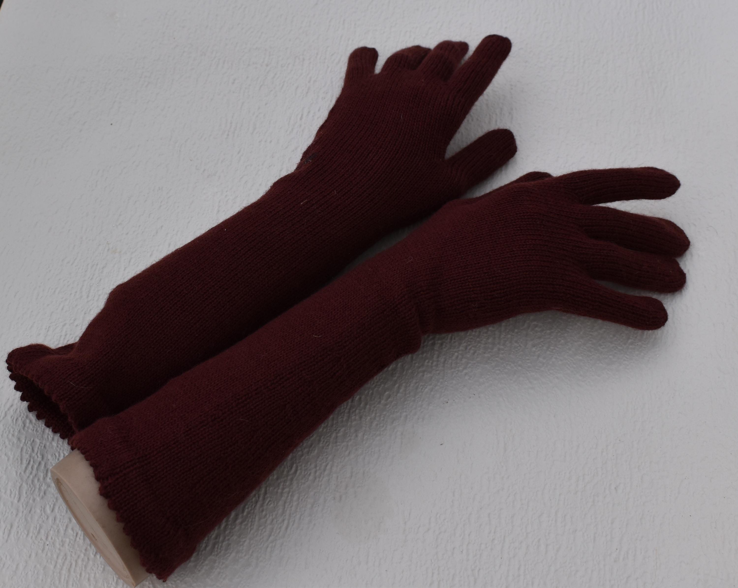 Pair of dark red gloves on a white background