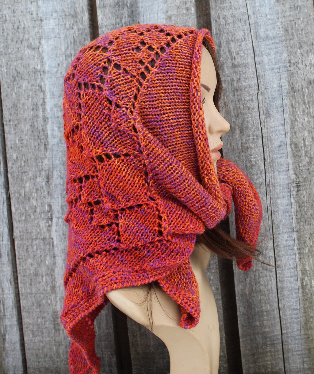 Knitted kerchief in orange on a mannequin against a wooden background