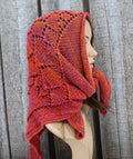Knitted kerchief in orange on a mannequin against a wooden background