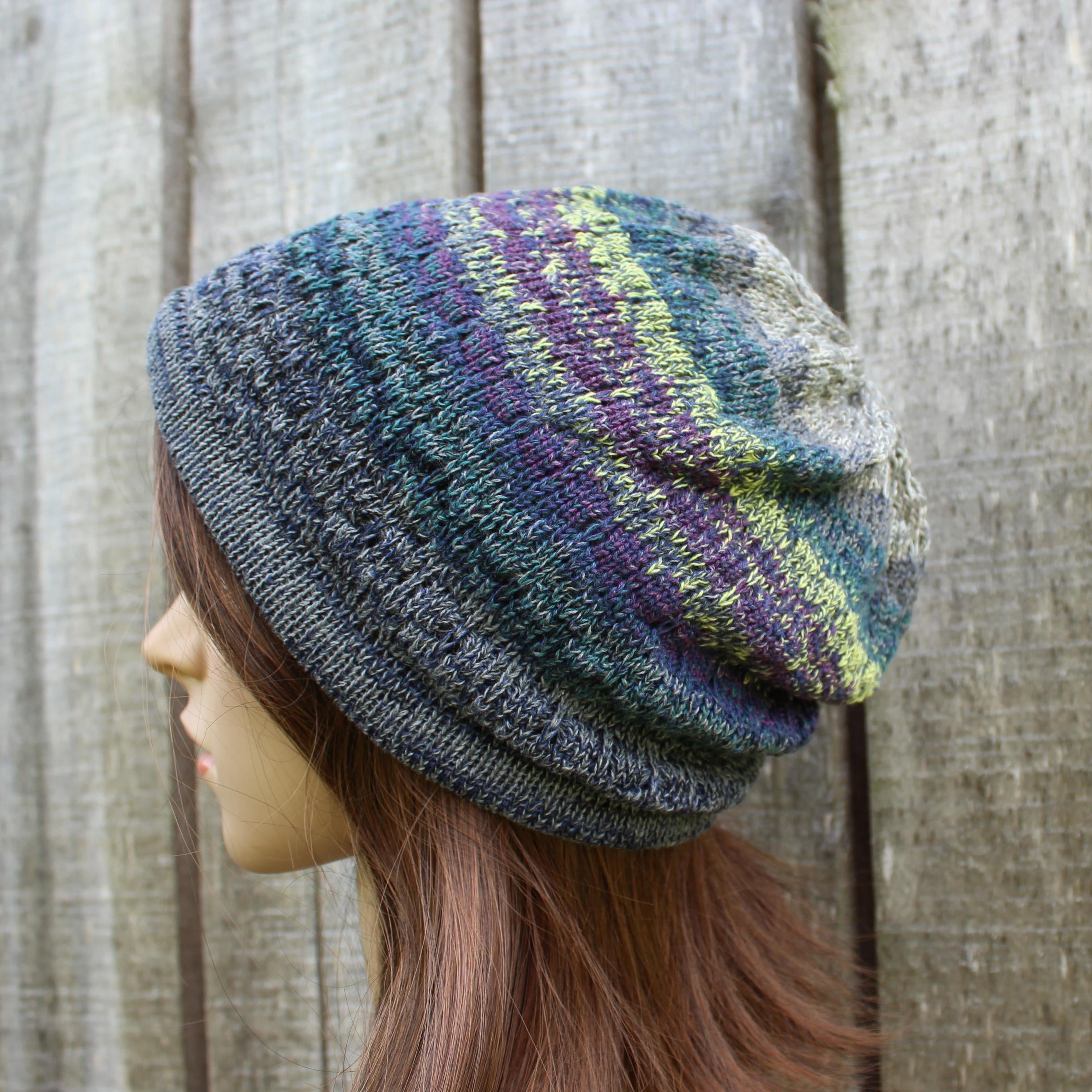 Multicolored knit beanie on a mannequin head against a wooden background