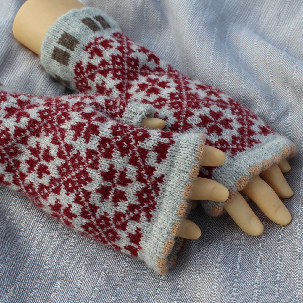 Pair of red and gray patterned fingerless gloves on a mannequin hand against a light blue fabric background.