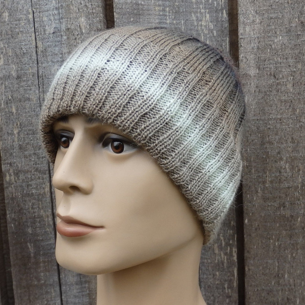 Knitted beanie on a mannequin head against a wooden background