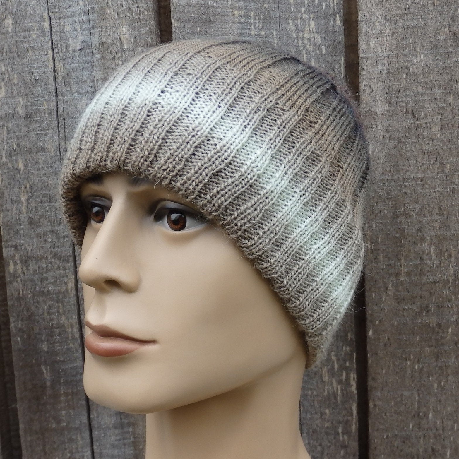 Knitted beanie on a mannequin head against a wooden background