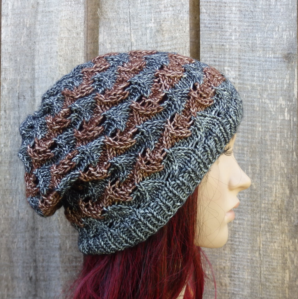 Knitted hat with a textured pattern worn by a mannequin against a wooden background