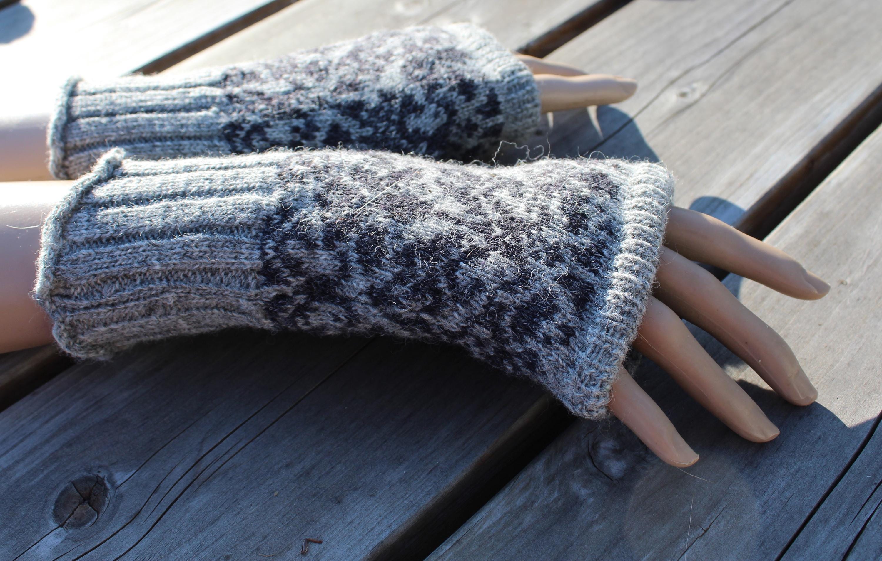 Pair of gray knitted fingerless gloves on a wooden surface